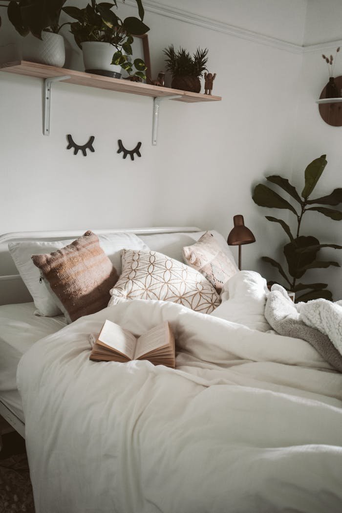 Services-02 Warm and inviting bedroom setup with decorative pillows, plants, and an open book for a cozy ambiance.