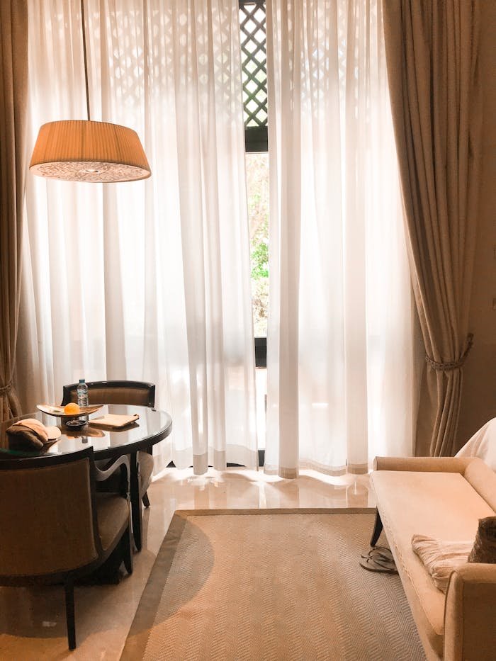 Cozy modern interior with sofa, table, and large window providing natural light.